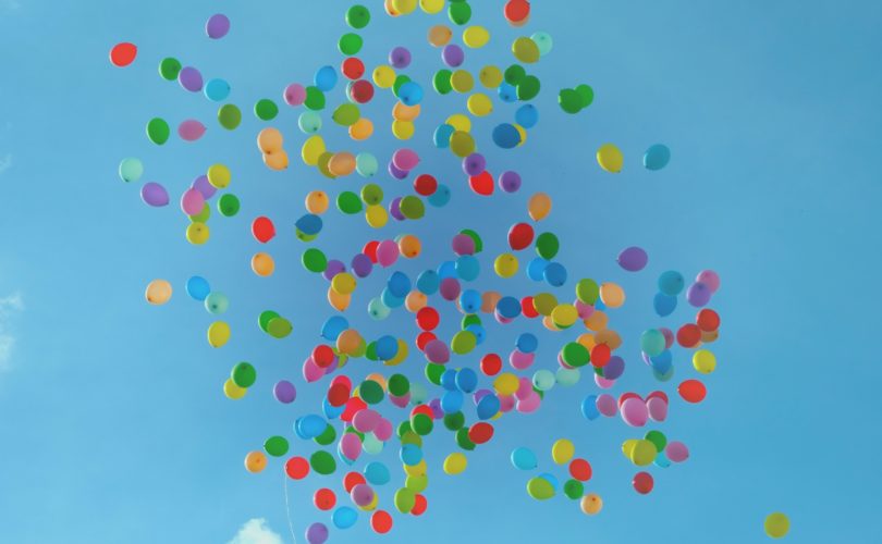 A bunch of balloons floating in the sky